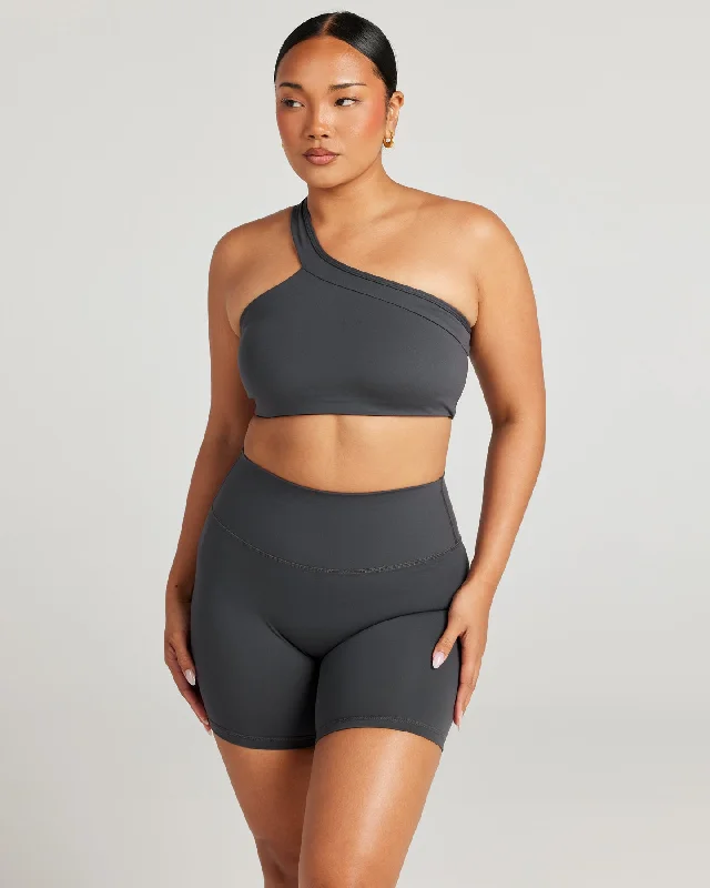 Compression sports bra – Sports bra that compresses the chest for a more secure fit and reduced bounce during high-impact activities.Aura Move Bra - Charcoal